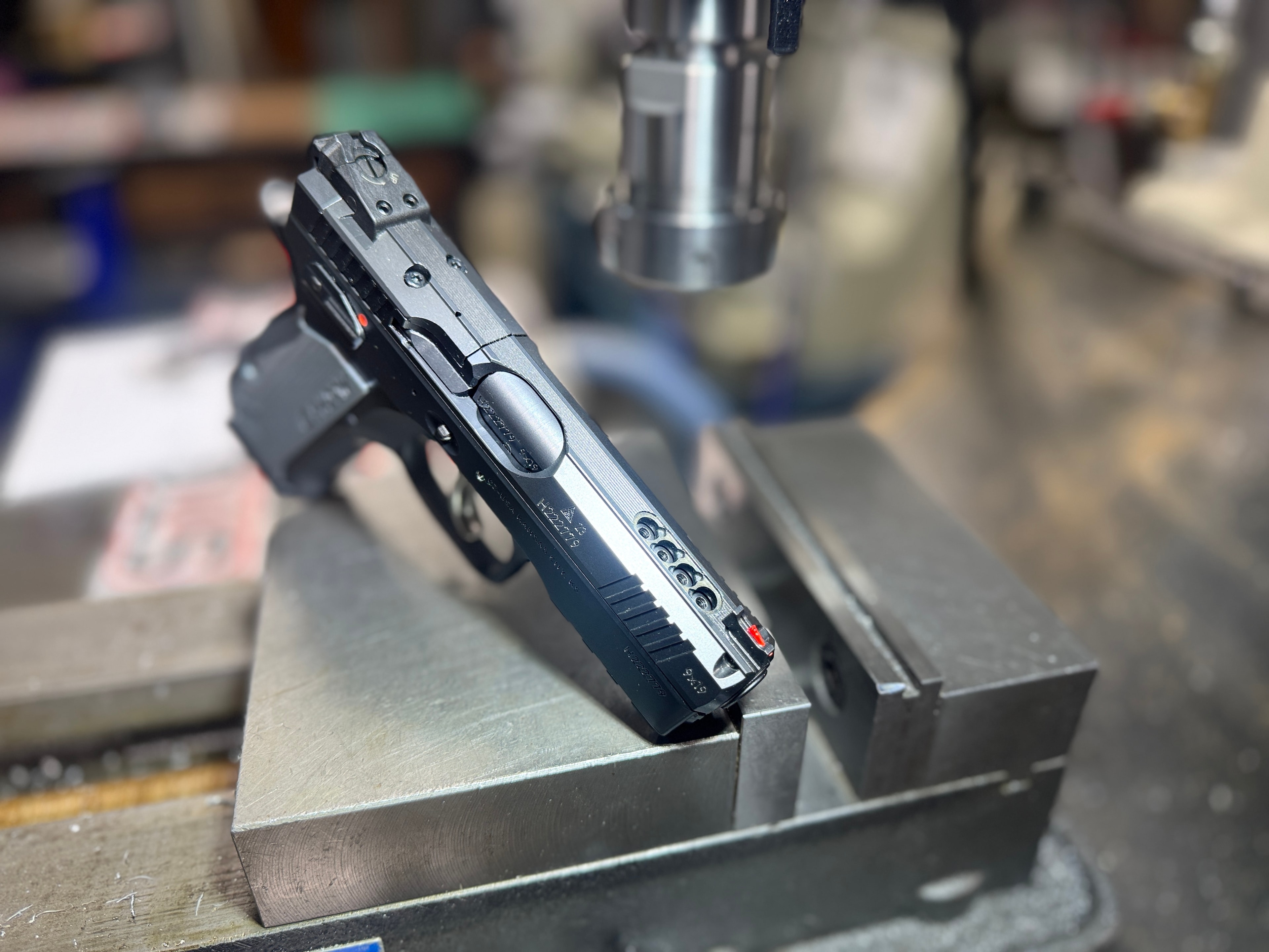 Semi-auto pistol slide on the drill press for optic cut milling work at Northwoods Firearms — precision machining, Crandon, WI