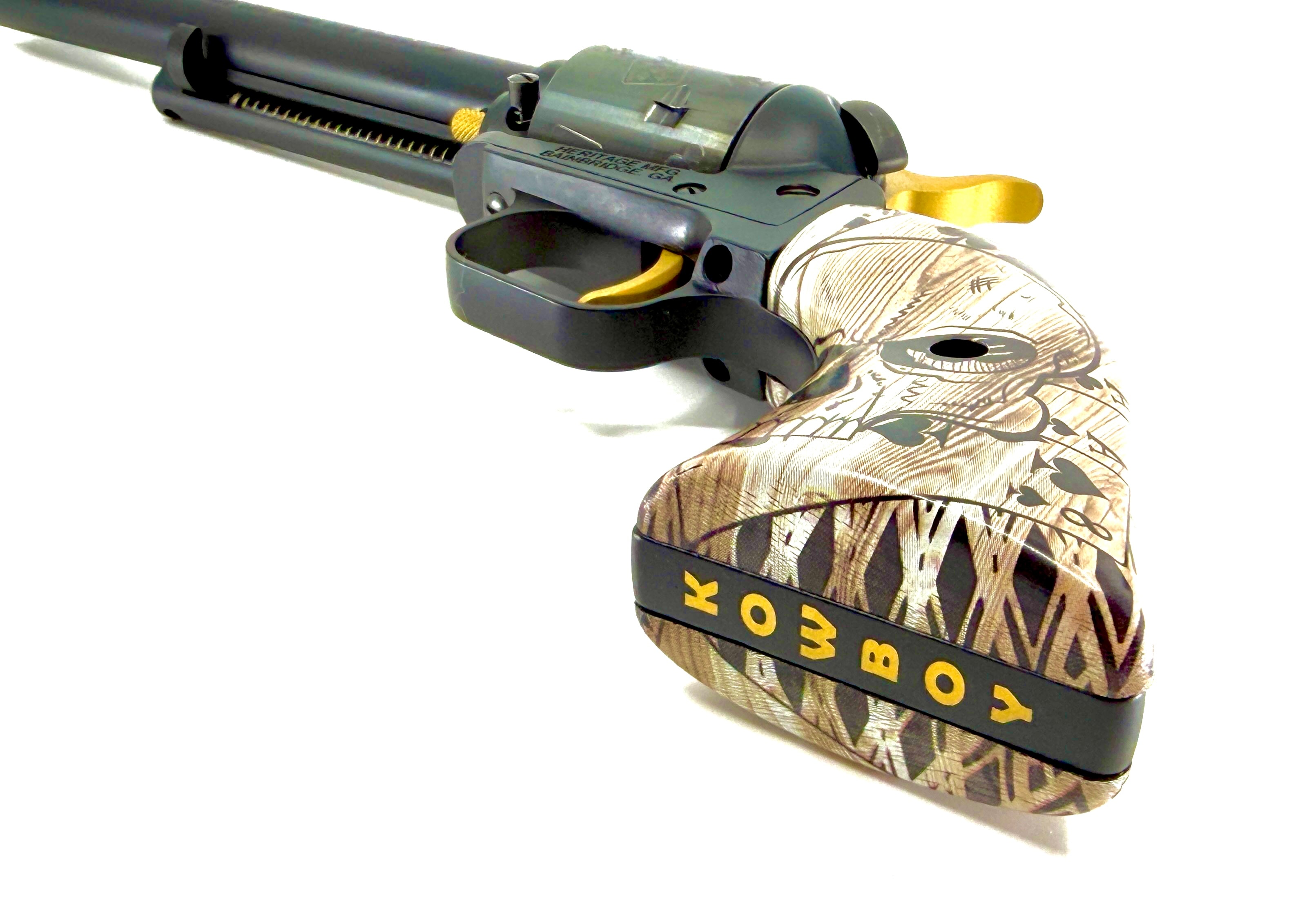 Laser-engraved Heritage Rough Rider revolver with COWBOY gold text on black band, skull and camo grip panels, gold hammer and trigger — by Northwoods Firearms
