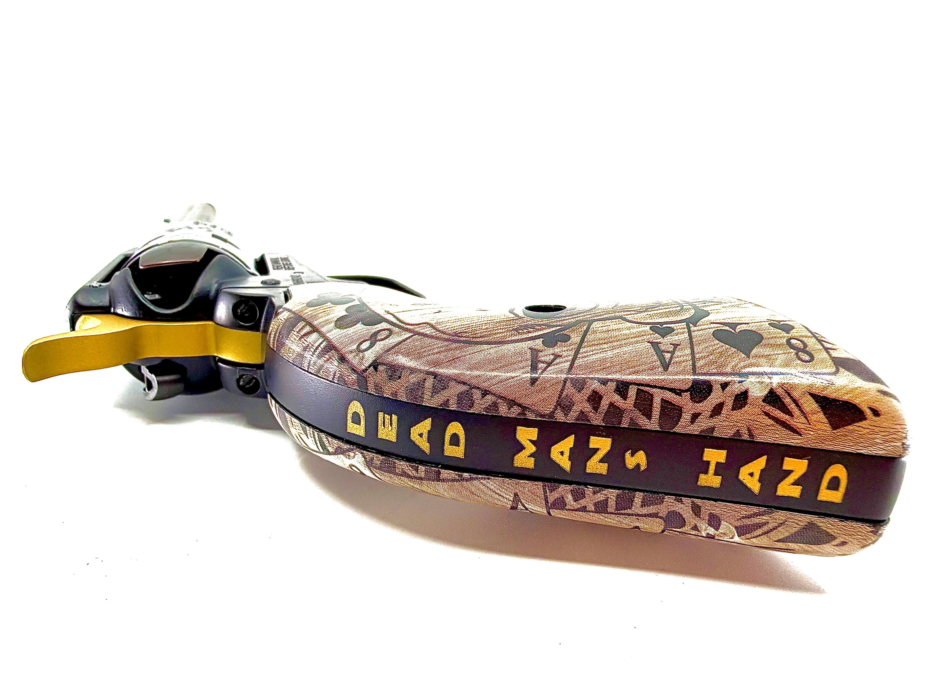 Laser-engraved Heritage revolver grip with Dead Man's Hand playing card and camo pattern, gold runic text on purple band — by Northwoods Firearms, Crandon, WI