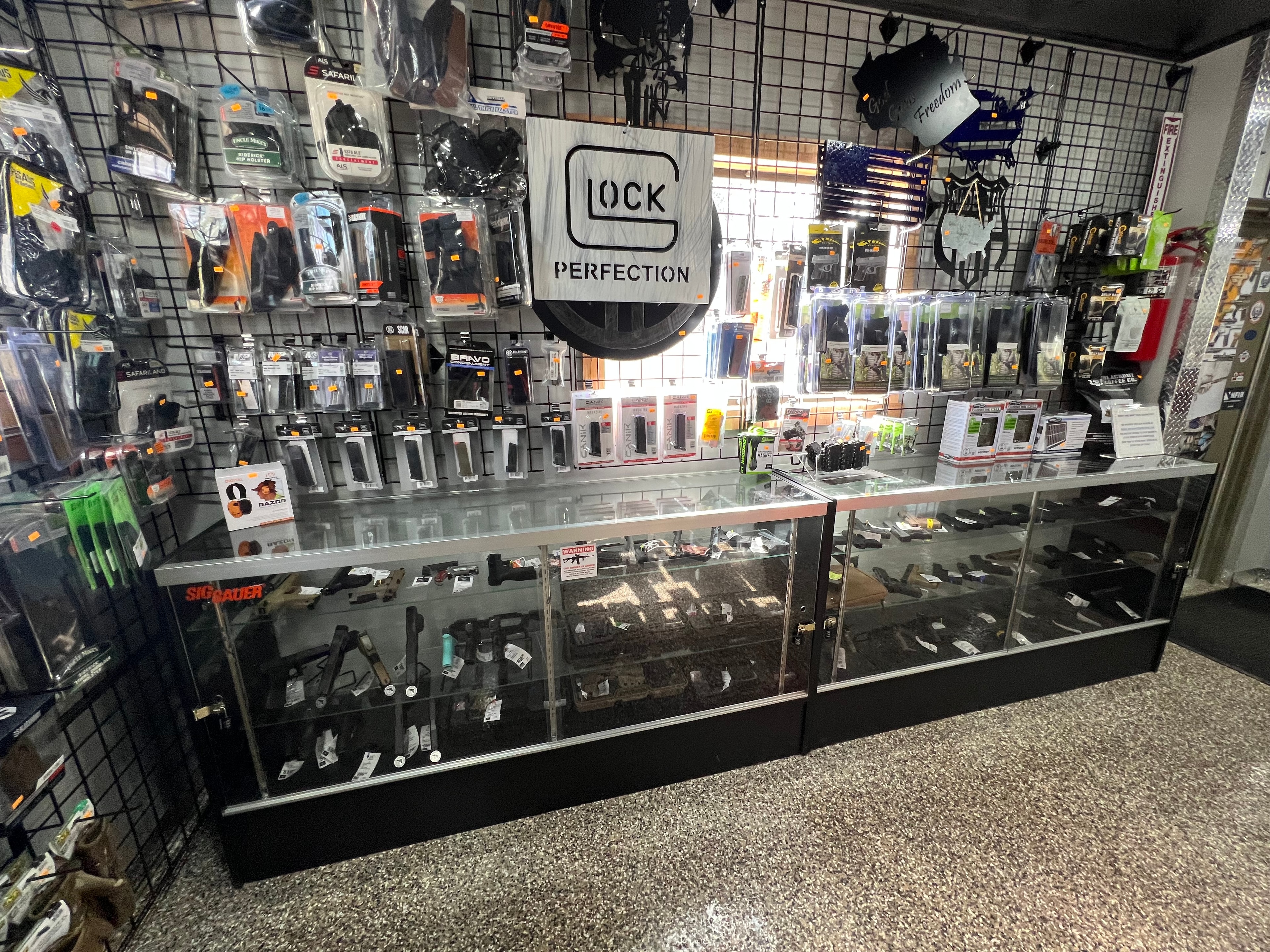 Northwoods Firearms Glock display case — handguns, holsters, Sig Sauer and Canik accessories, Glock Perfection sign