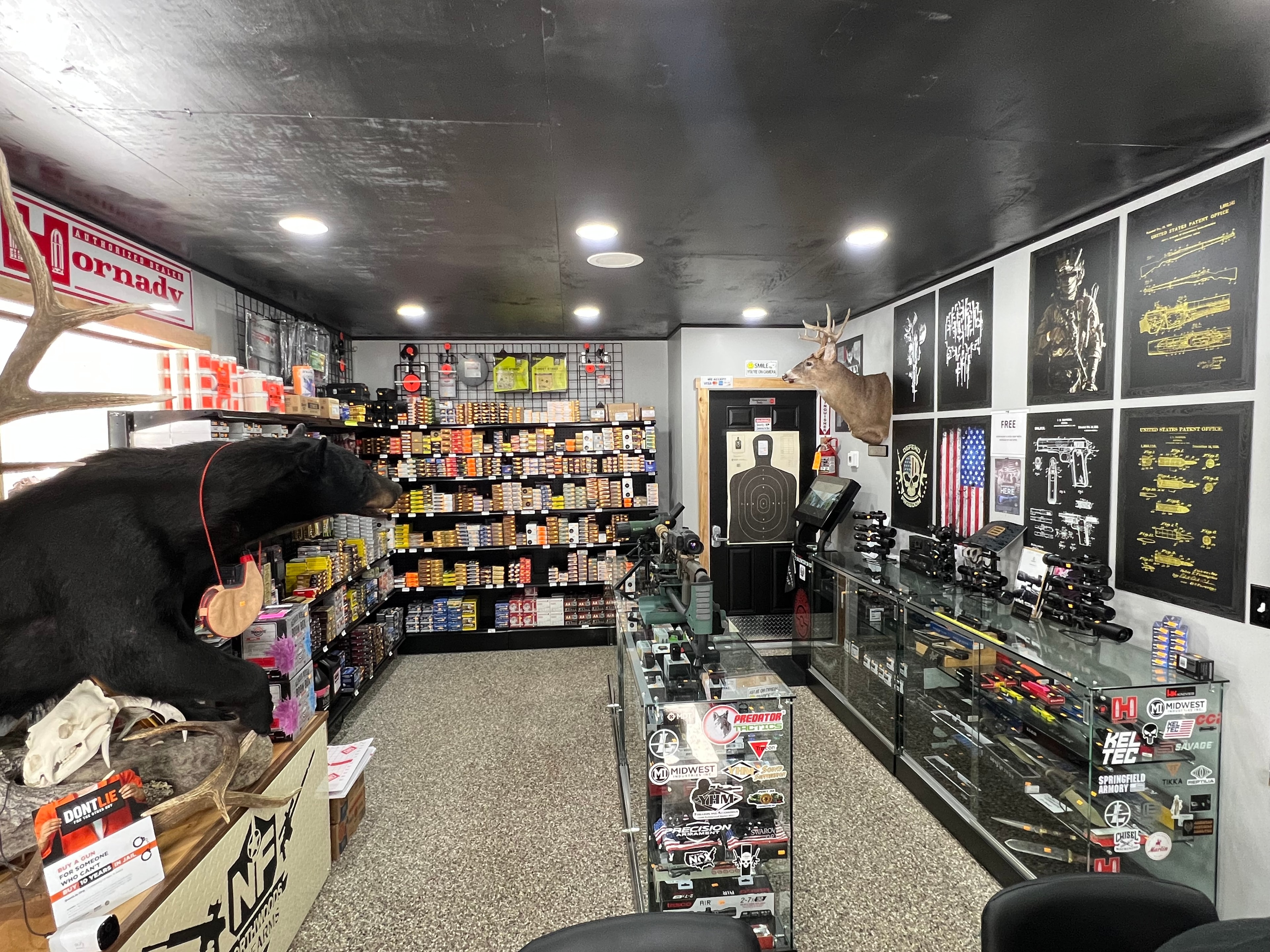 Northwoods Firearms interior overview — ammo shelves, display cases, deer mount, and Hornady authorized dealer signage