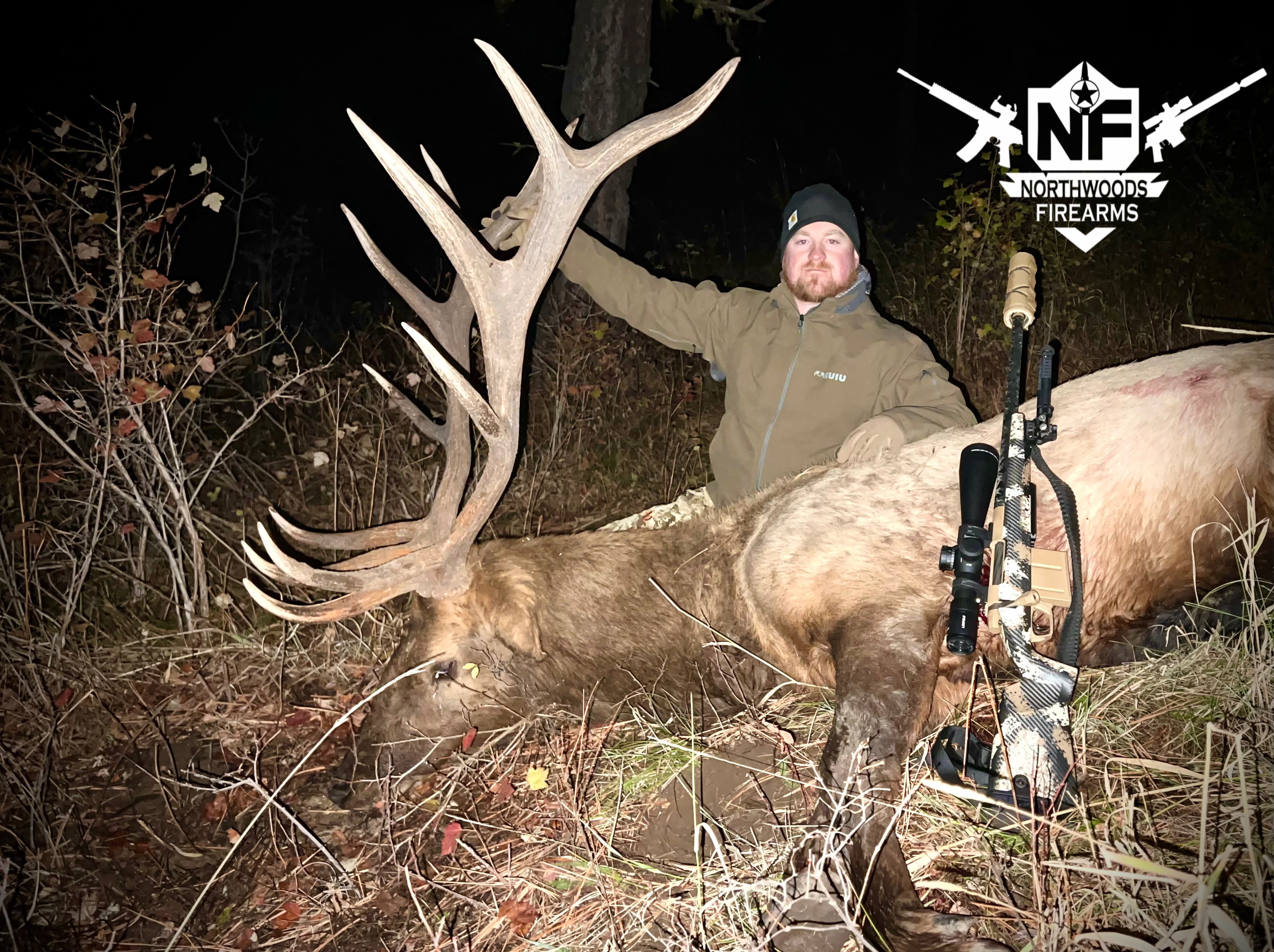 Bobby Connor with trophy bull elk and Northwoods Firearms custom precision rifle at night
