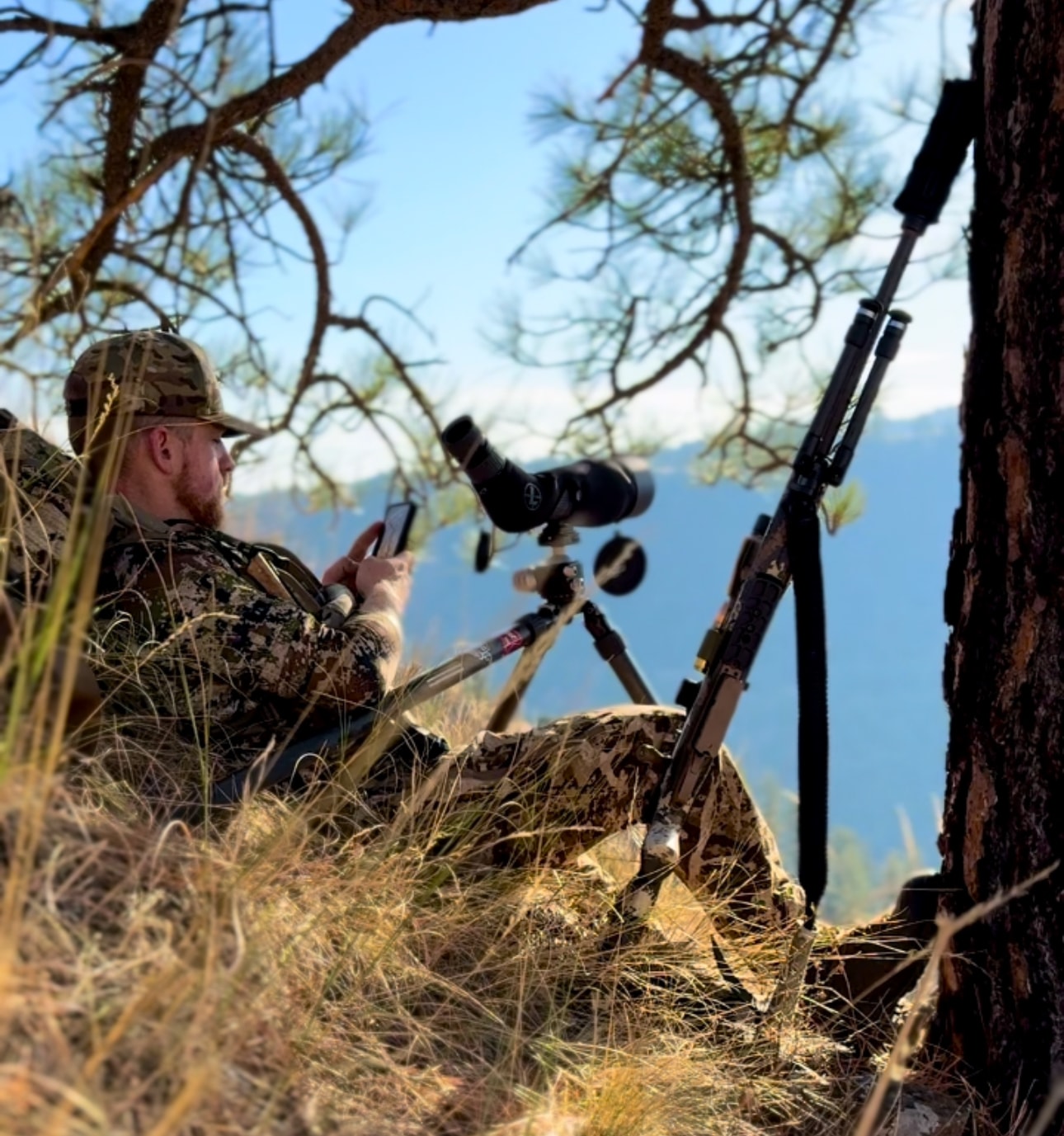 Bobby Connor glassing from ridge with spotting scope and rifle